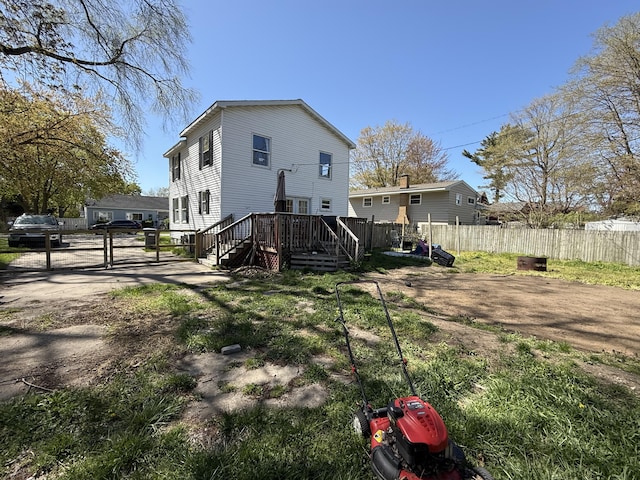 back of property with a wooden deck and fence