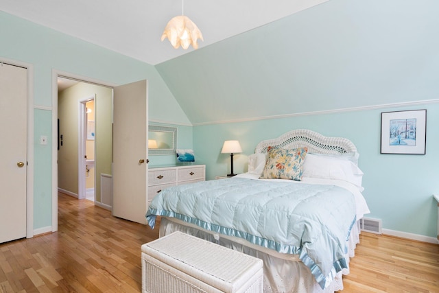 bedroom with wood finished floors, lofted ceiling, and baseboards