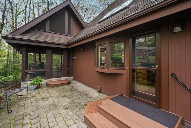rear view of property featuring a patio and roof with shingles