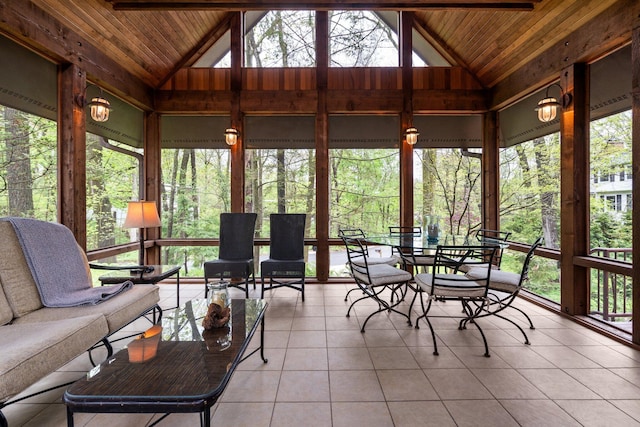 sunroom with vaulted ceiling, wood ceiling, tile patterned floors, outdoor dining space, and healthy amount of natural light