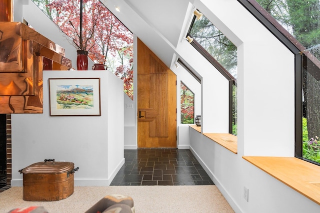 entrance foyer with stone tile floors, baseboards, and healthy amount of natural light