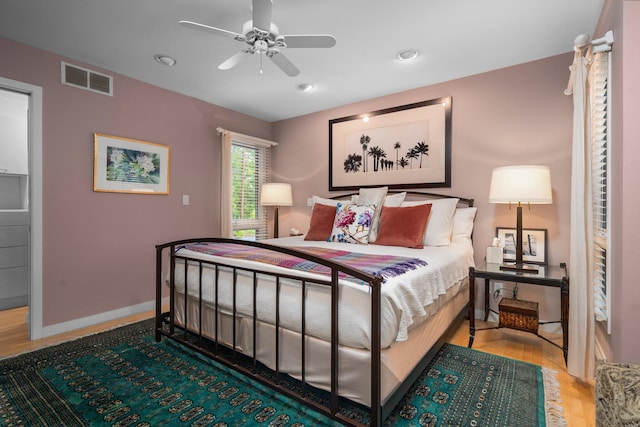bedroom with wood finished floors, baseboards, and recessed lighting