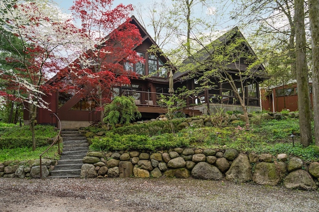 rear view of property featuring stairs and a sunroom
