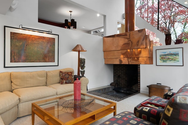 carpeted living area with a brick fireplace and baseboards