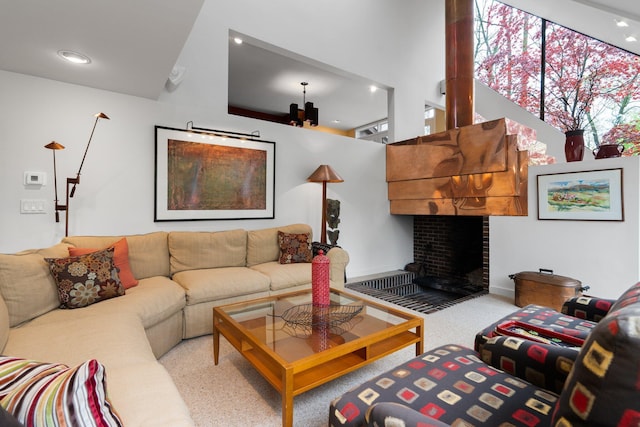 carpeted living room featuring recessed lighting, a fireplace, a high ceiling, and baseboards
