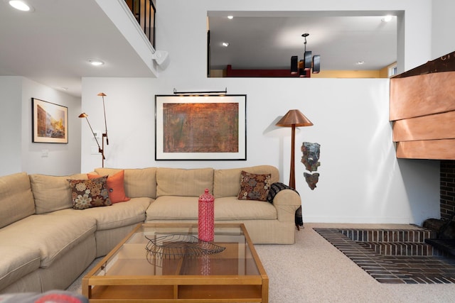 carpeted living area featuring a brick fireplace and recessed lighting