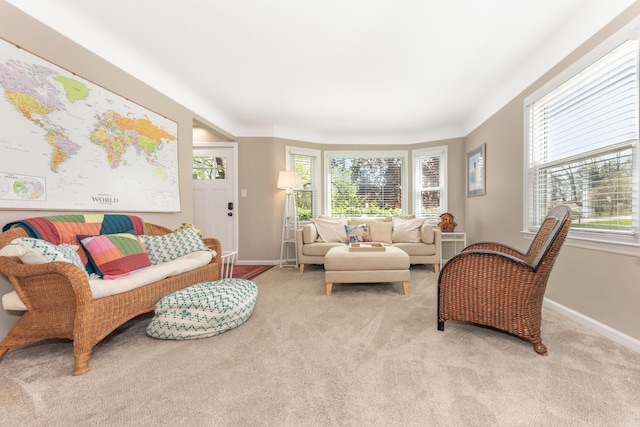 living room with healthy amount of natural light, light colored carpet, and baseboards