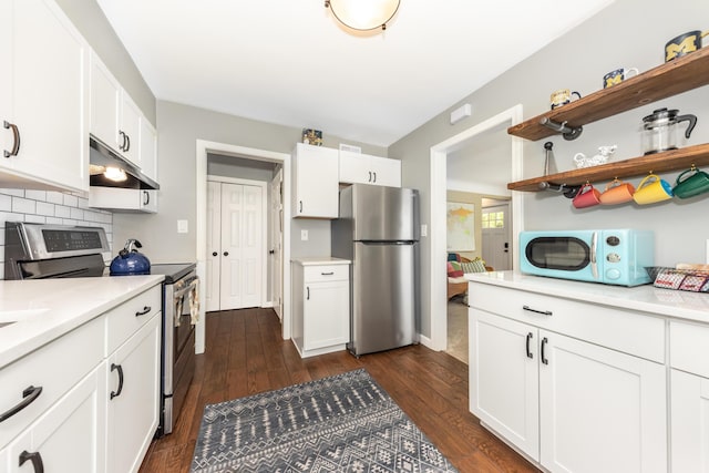 kitchen featuring appliances with stainless steel finishes, under cabinet range hood, light countertops, dark wood-type flooring, and white cabinets