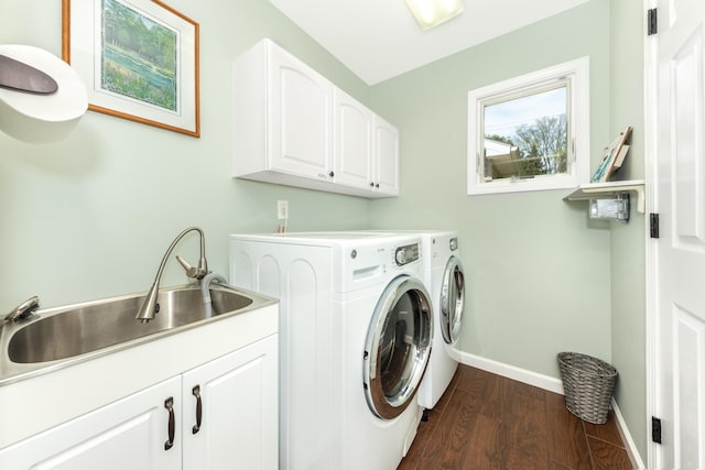 clothes washing area with cabinet space, washing machine and dryer, baseboards, and dark wood-style flooring