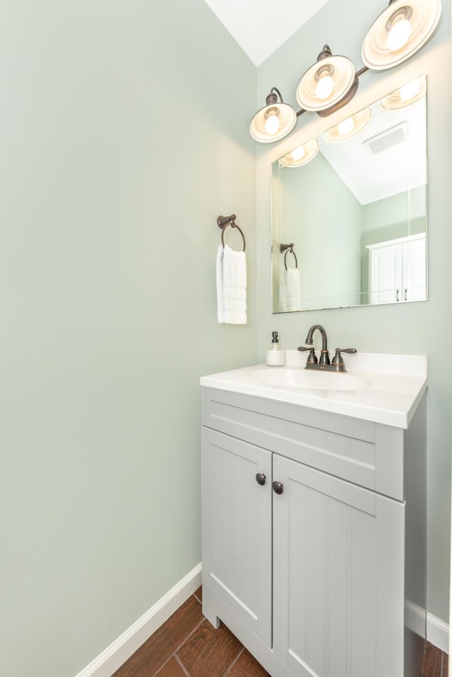 bathroom with baseboards, wood finished floors, and vanity