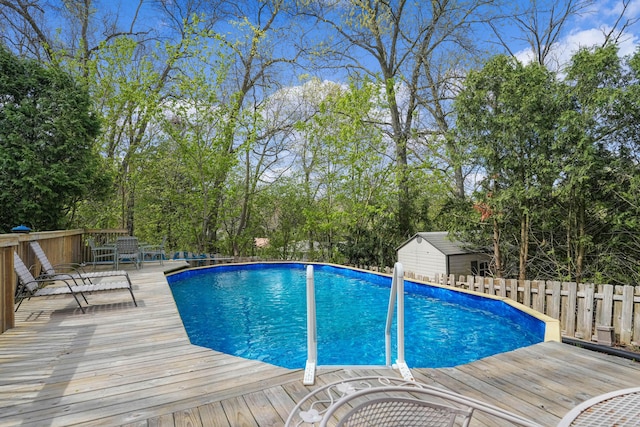 2394 Cedar Crest Dr NE, Grand Rapids, MI 49525 - view of swimming pool with a deck, view of scattered trees, fence, and an outbuilding