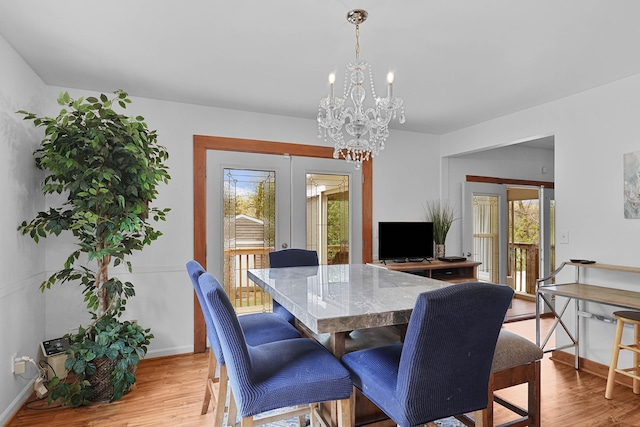 2394 Cedar Crest Dr NE, Grand Rapids, MI 49525 - dining space featuring french doors, a chandelier, light wood-style floors, and baseboards