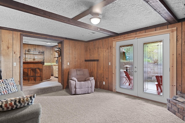 2394 Cedar Crest Dr NE, Grand Rapids, MI 49525 - living area with french doors, beamed ceiling, carpet, wood walls, and a textured ceiling