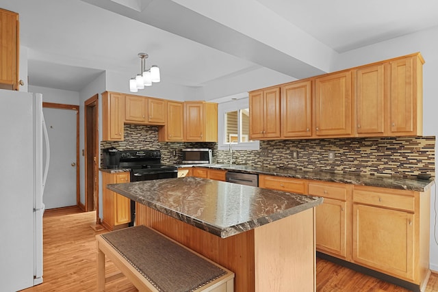 2394 Cedar Crest Dr NE, Grand Rapids, MI 49525 - kitchen featuring black range, freestanding refrigerator, backsplash, light wood finished floors, and a center island
