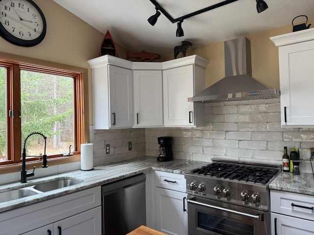 15205 Riverview Rd SE, Grayling, MI 49738 - kitchen featuring wall chimney range hood, high end stove, dishwashing machine, a sink, and backsplash