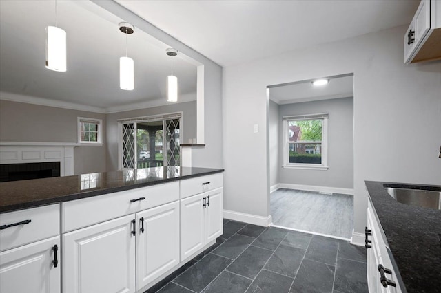 kitchen with a sink, dark countertops, and white cabinetry
