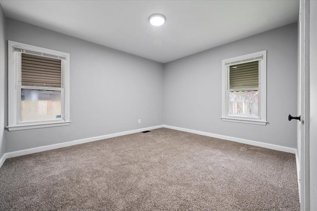 spare room with carpet and baseboards