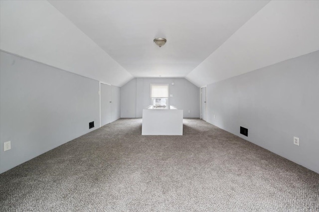 bonus room with light colored carpet and vaulted ceiling