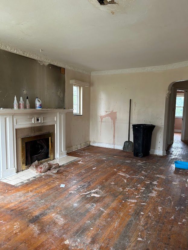 unfurnished living room with a fireplace, hardwood / wood-style floors, arched walkways, healthy amount of natural light, and crown molding