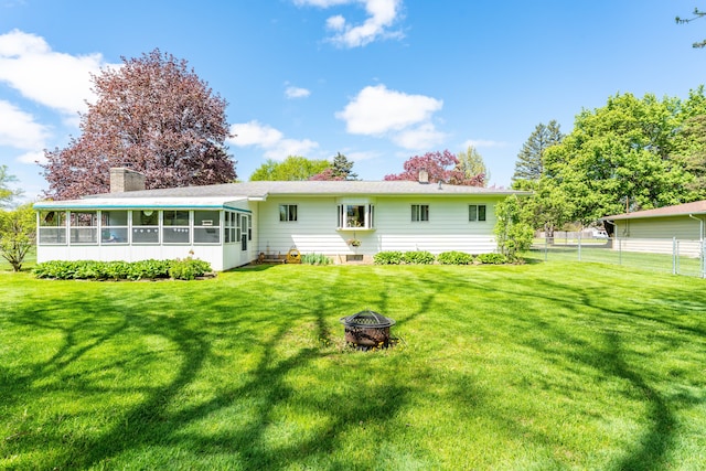 5200 N Jennings Rd, Flint, MI 48504 - back of house featuring a sunroom, an outdoor fire pit, and a chimney