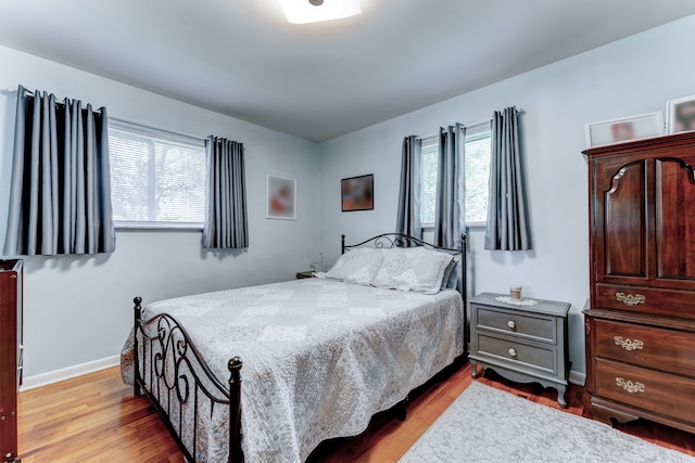 5200 N Jennings Rd, Flint, MI 48504 - bedroom with multiple windows, wood finished floors, and baseboards