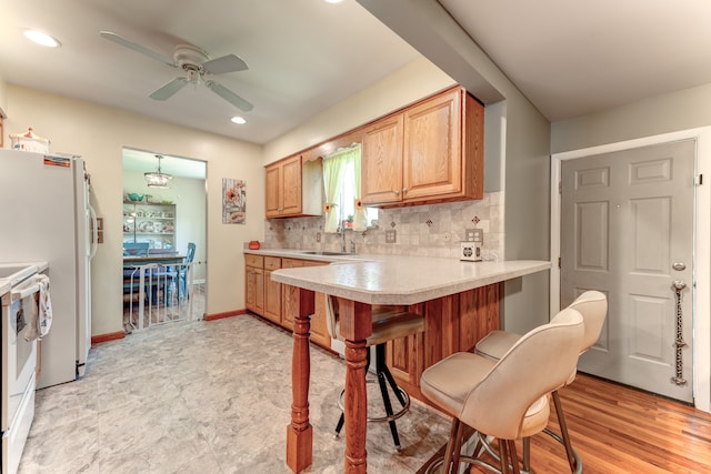 5200 N Jennings Rd, Flint, MI 48504 - kitchen with ceiling fan, light countertops, a sink, white appliances, and a kitchen breakfast bar