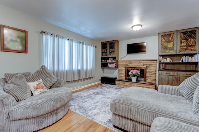5200 N Jennings Rd, Flint, MI 48504 - living room with wood finished floors, a stone fireplace, and baseboards