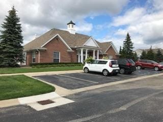 view of front of home featuring uncovered parking and a front lawn
