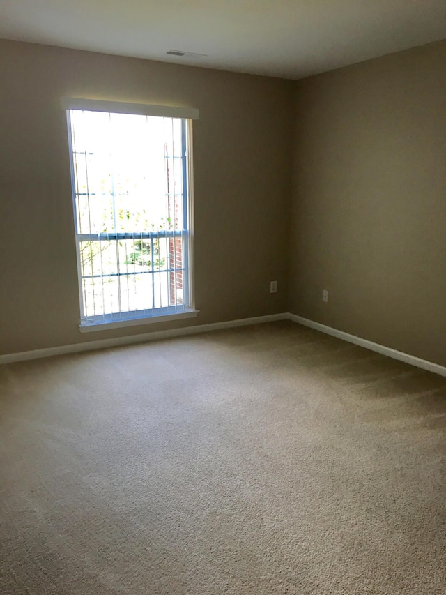 empty room featuring baseboards and plenty of natural light