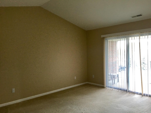 carpeted empty room with vaulted ceiling, healthy amount of natural light, and baseboards