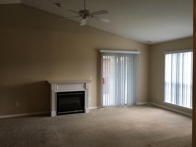 unfurnished living room with vaulted ceiling, a ceiling fan, carpet, and plenty of natural light