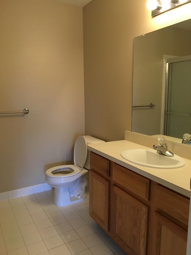 bathroom featuring tile patterned floors, a shower stall, vanity, toilet, and baseboards