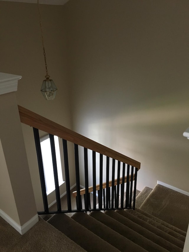 stairway featuring carpet and baseboards