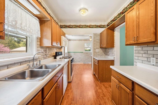 220 S Berrien St, New Buffalo, MI 49117 - kitchen featuring white appliances, a sink, light countertops, brown cabinetry, and light wood-style flooring