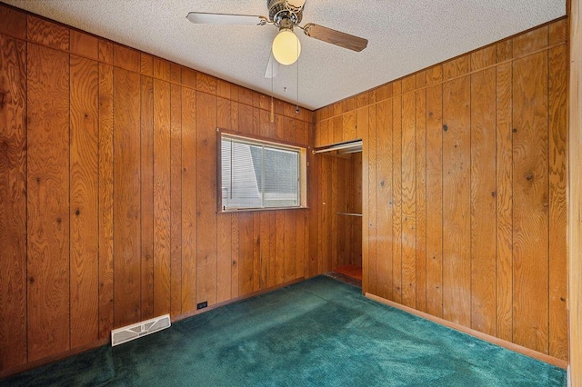 220 S Berrien St, New Buffalo, MI 49117 - unfurnished room featuring carpet floors, a textured ceiling, wooden walls, and ceiling fan