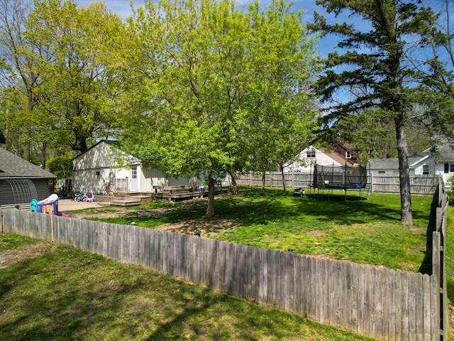 view of yard with a trampoline and a wooden deck