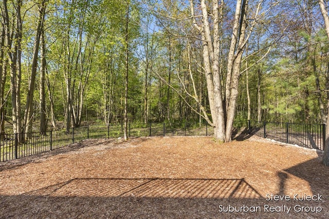view of yard featuring fence and a forest view