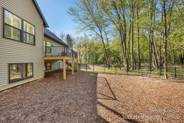 fenced backyard with a deck and stairs