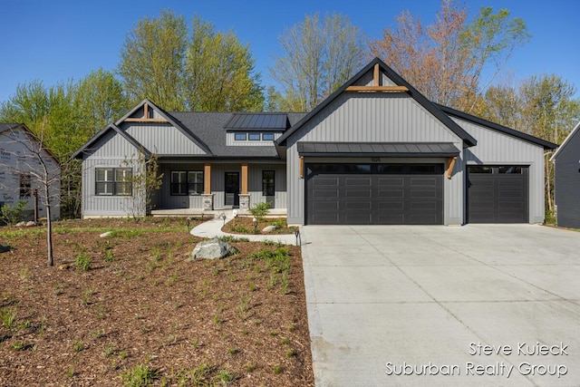 modern farmhouse style home featuring a standing seam roof, a garage, board and batten siding, a porch, and driveway