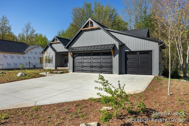 modern farmhouse style home featuring driveway, a garage, board and batten siding, a standing seam roof, and metal roof