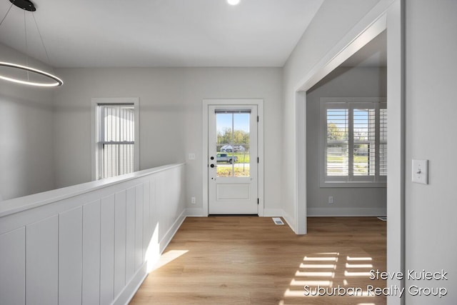 entryway with light wood-style floors and baseboards