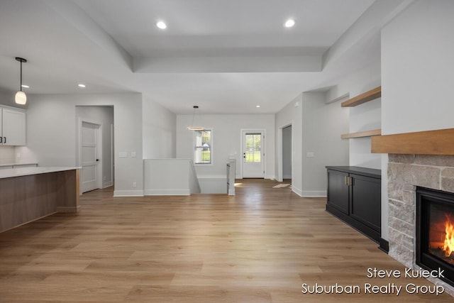 unfurnished living room featuring a fireplace, light wood finished floors, recessed lighting, and baseboards