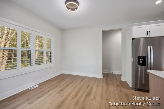 unfurnished dining area featuring light wood-type flooring, baseboards, and recessed lighting