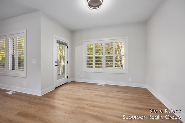 unfurnished dining area with plenty of natural light, baseboards, and light wood-style floors