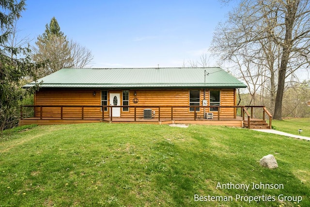 back of house featuring a yard, a wooden deck, central AC, log veneer siding, and metal roof