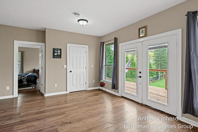 doorway to outside with french doors, wood finished floors, and baseboards