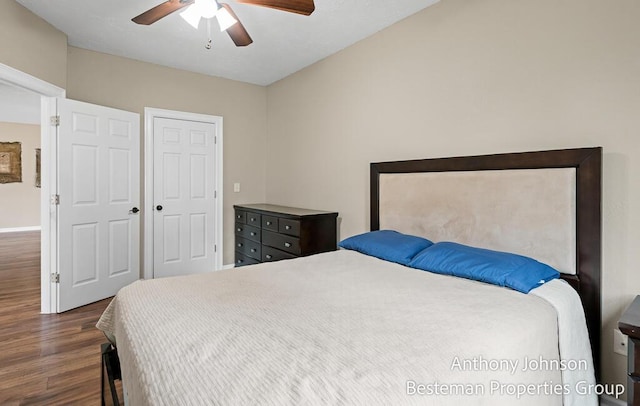 bedroom with dark wood-style flooring, a ceiling fan, and baseboards