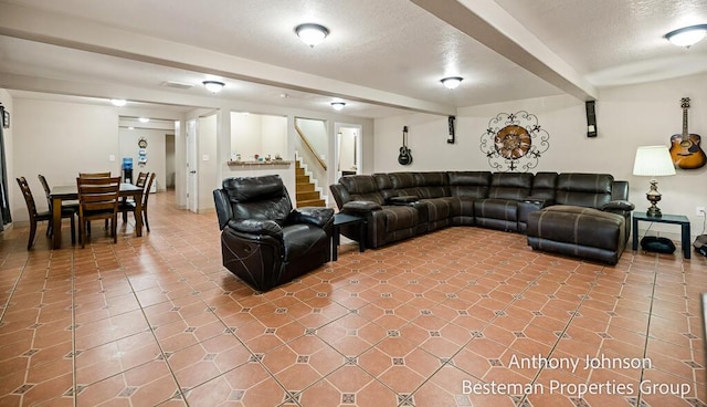 living room with stairs, a textured ceiling, and tile patterned flooring