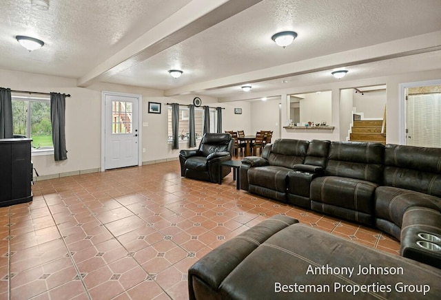 tiled living area featuring a textured ceiling, baseboards, and beamed ceiling