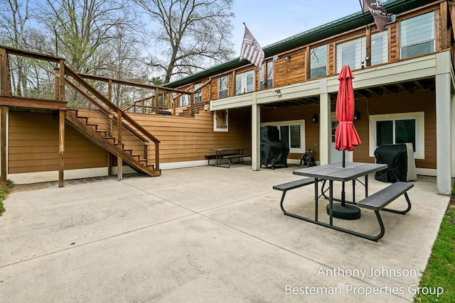 rear view of property with stairway, a patio, and outdoor dining space